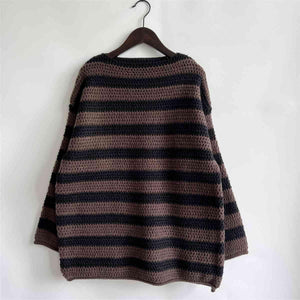 a brown and black striped sweater hanging on a wall