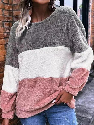 a woman wearing a grey, pink and white sweater