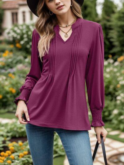 a woman wearing a hat and a purple top