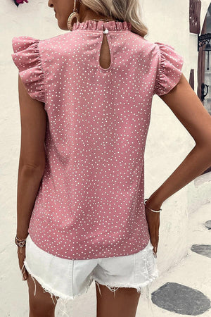a woman wearing a pink top with white polka dots