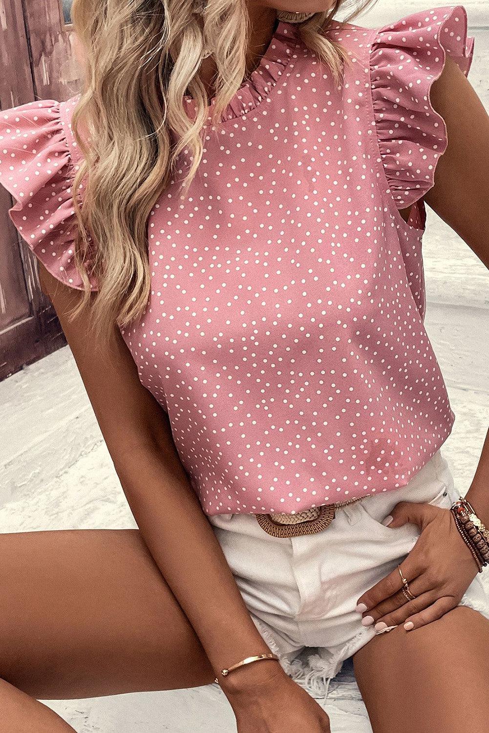 a woman wearing a pink top with white polka dots