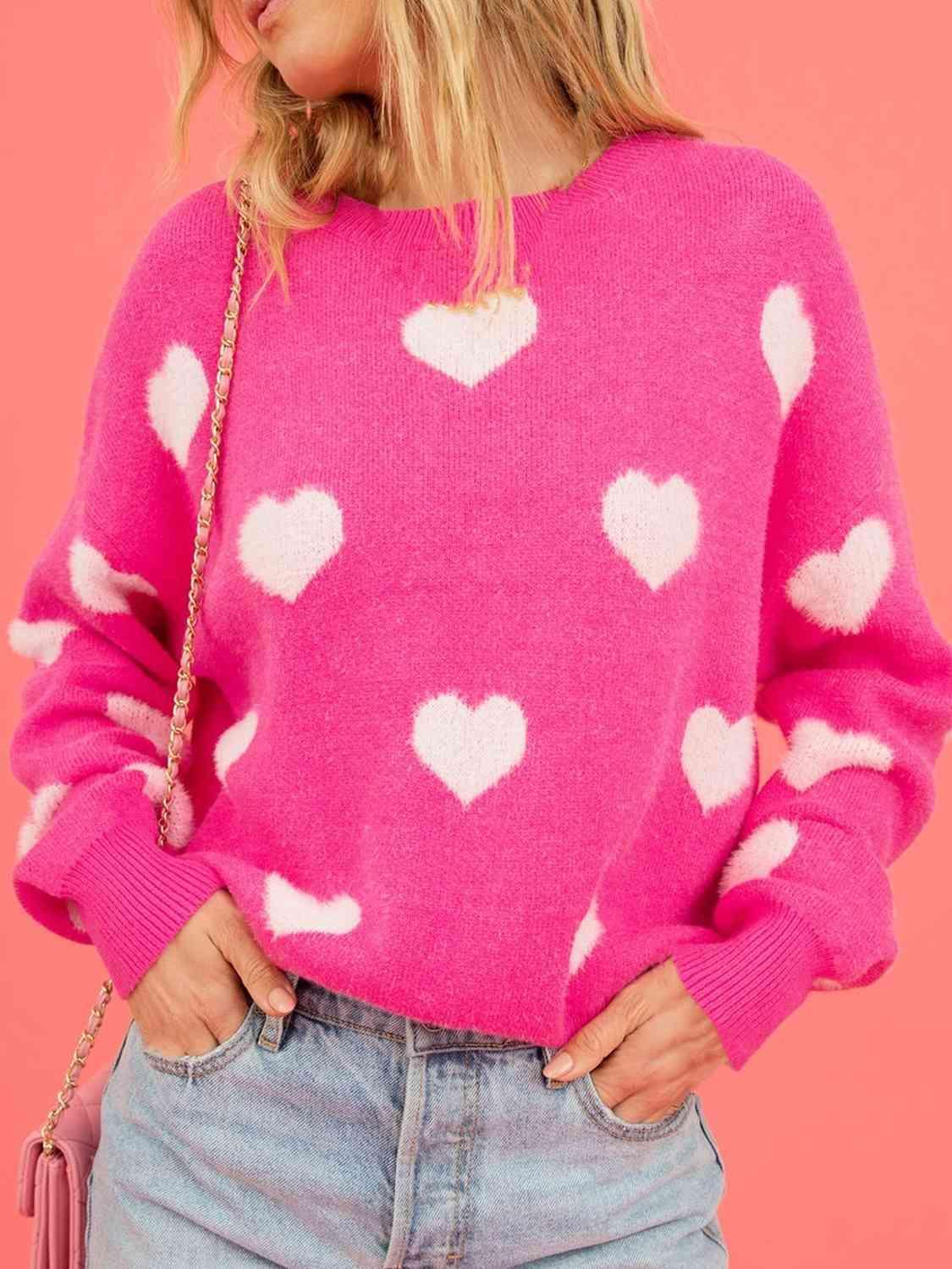 a woman wearing a pink sweater with white hearts on it