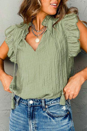 a woman wearing a green top and jeans