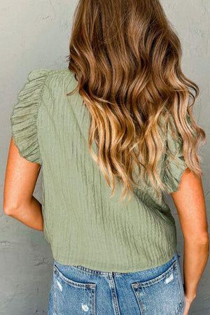 a woman standing against a wall with her back to the camera