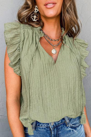 a woman wearing a green top and jeans