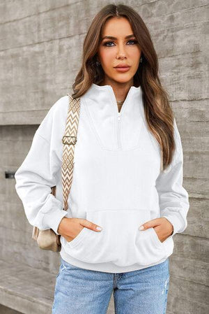 a woman wearing a white sweatshirt and jeans