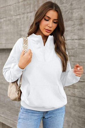 a woman wearing a white hoodie and jeans