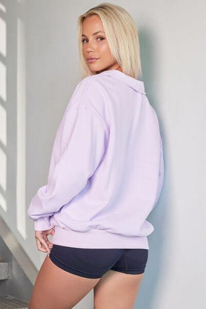 a woman in a purple sweatshirt and black shorts