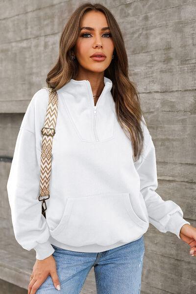 a woman wearing a white hoodie and jeans