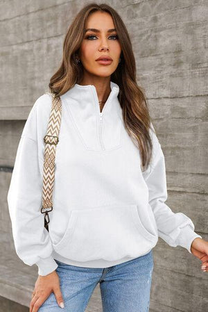 a woman wearing a white hoodie and jeans