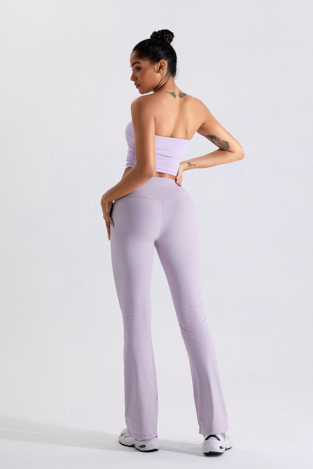 a woman in a white top and purple pants
