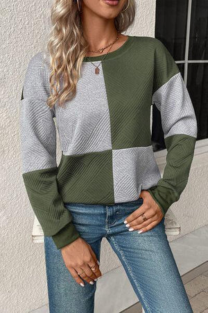 a woman wearing a green and grey sweater