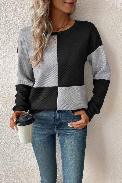 a woman wearing jeans and a sweater holding a coffee cup