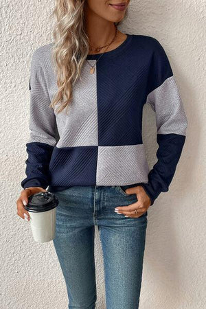 a woman wearing jeans and a sweater holding a coffee cup