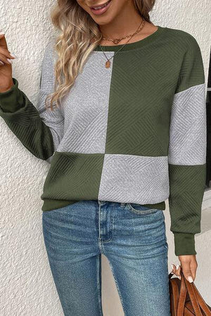 a woman wearing a green and grey sweater