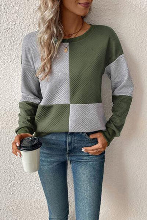 a woman in jeans and a sweater holding a coffee cup
