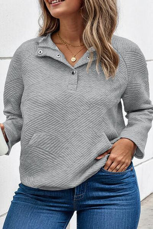 a woman wearing a gray sweater and jeans