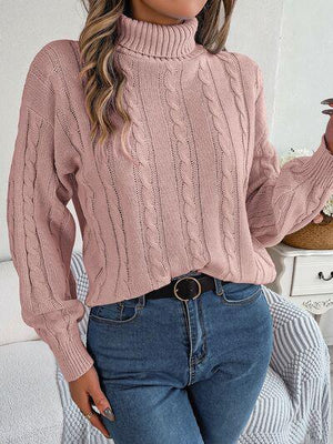 a woman wearing a pink sweater and jeans