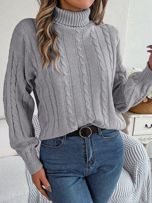 a woman wearing a gray sweater and jeans