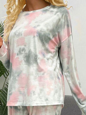 a woman with blonde hair wearing a tie dye top and pajama pants