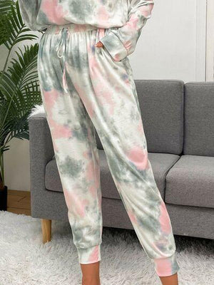a woman wearing a tie dye jumpsuit in a living room