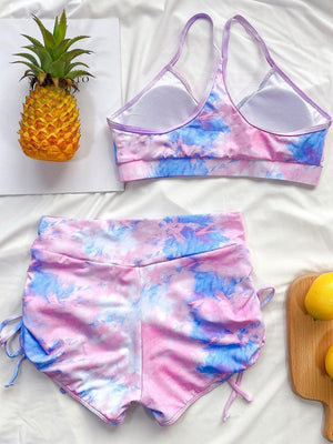 a pink and blue tie dye bikini set next to a pineapple