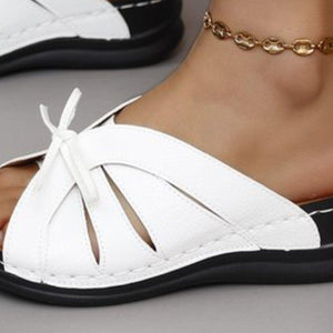 a close up of a person wearing white sandals