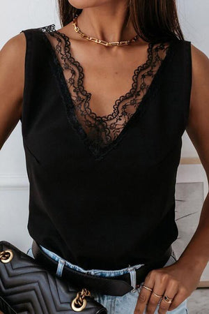 a woman wearing a black top and jeans holding a black purse