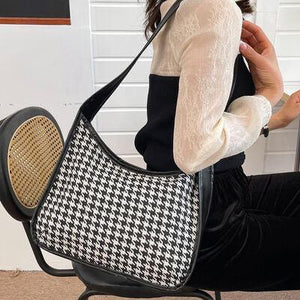 a woman sitting on a chair holding a purse