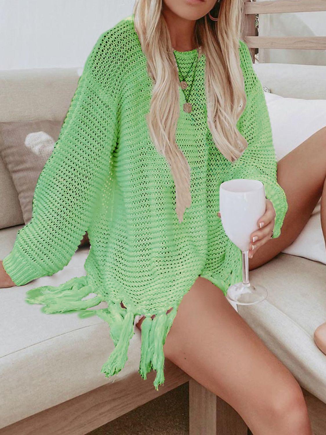 a woman sitting on a couch wearing a green sweater