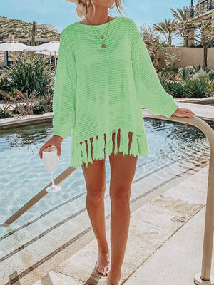 a woman wearing a green sweater and shorts
