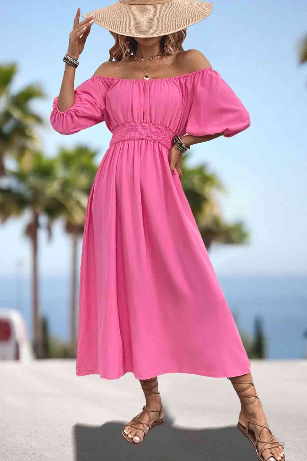 a woman wearing a pink dress and a straw hat