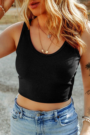 a woman wearing a black crop top and jeans