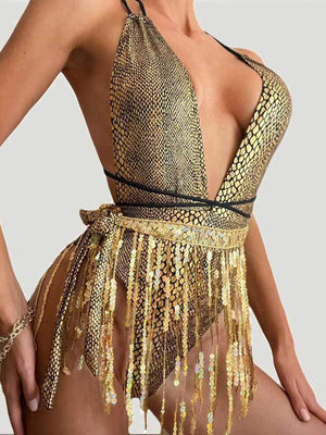 a woman wearing a gold bodysuit with gold sequins