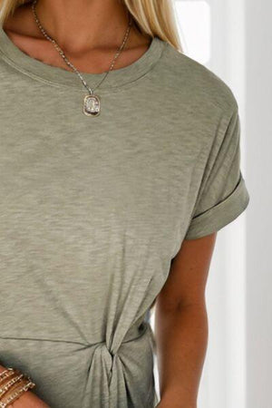 a woman wearing a necklace and a green shirt