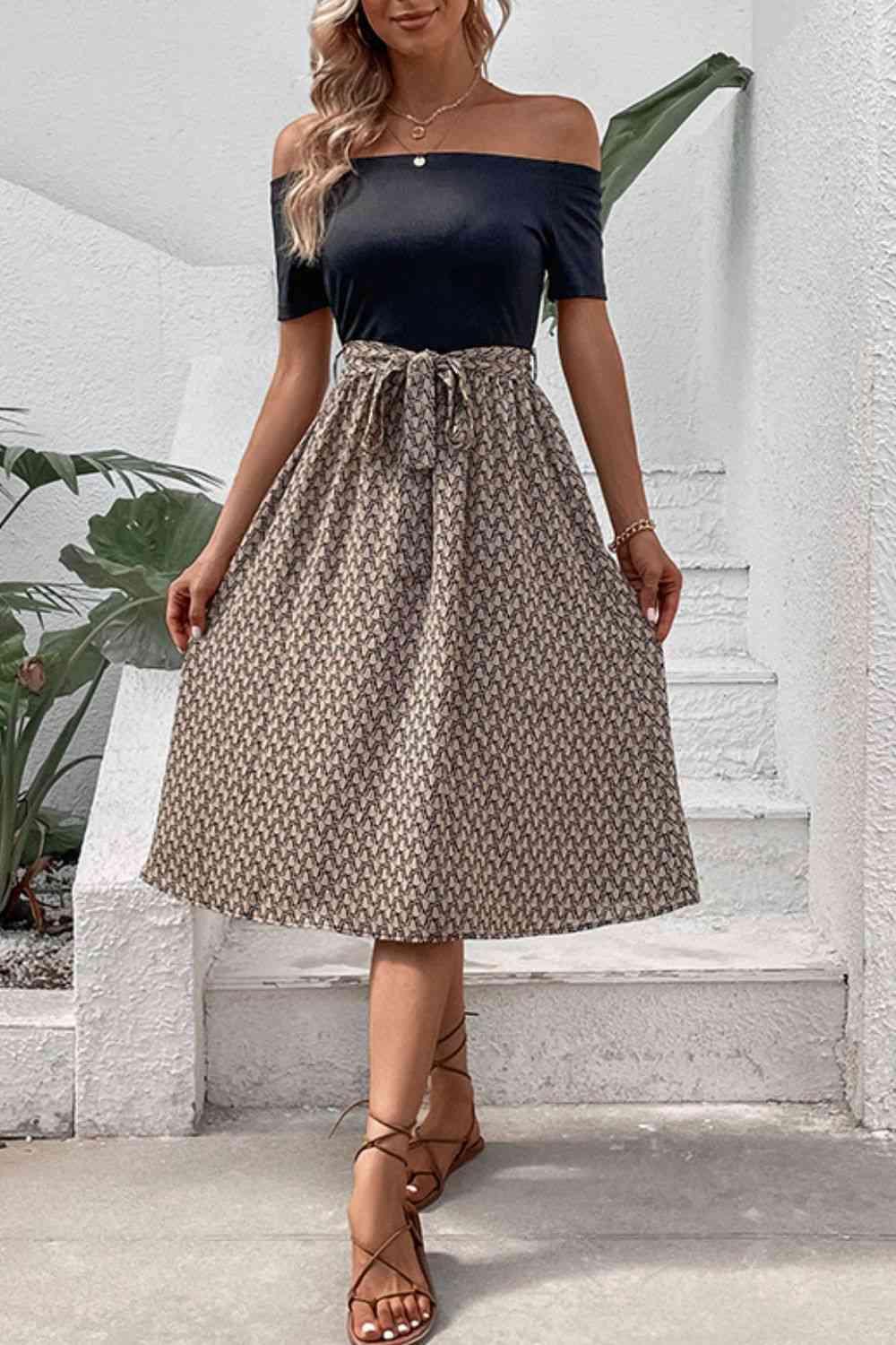 a woman in a black top and brown skirt
