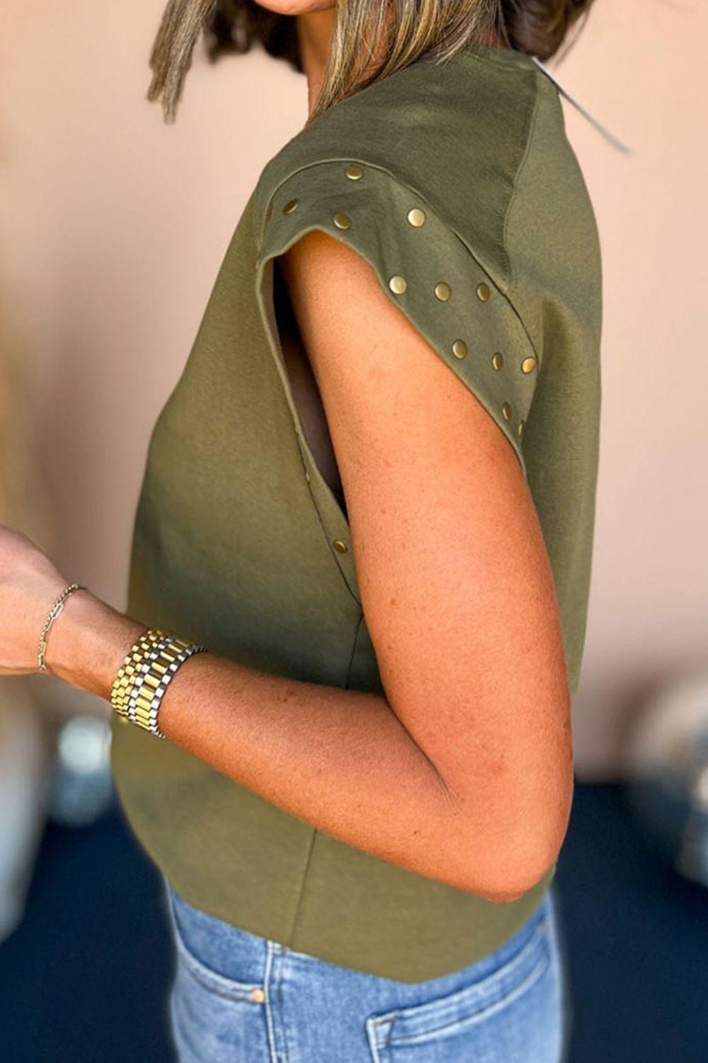 a woman in a green shirt is holding a cell phone