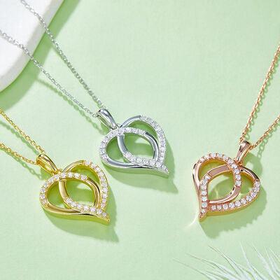 three necklaces on a green surface with a feather