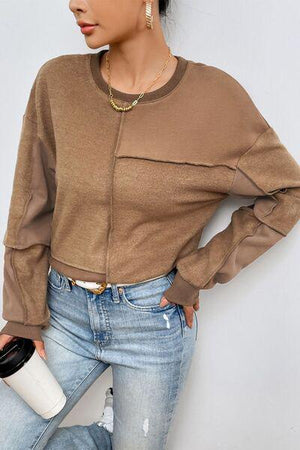 a woman is leaning against a wall with her hand on her hip