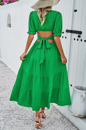 a woman wearing a green dress and a straw hat
