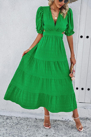 a woman wearing a green dress and straw hat