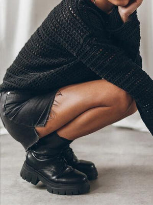 a woman sitting on the ground with her legs crossed