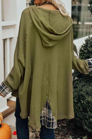 a woman wearing a green sweater and jeans