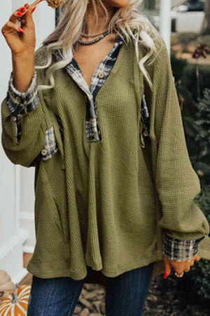 a woman wearing a green shirt and jeans