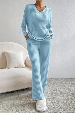 a woman wearing a blue sweater and pants