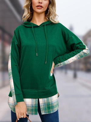 a woman wearing a green hoodie and jeans