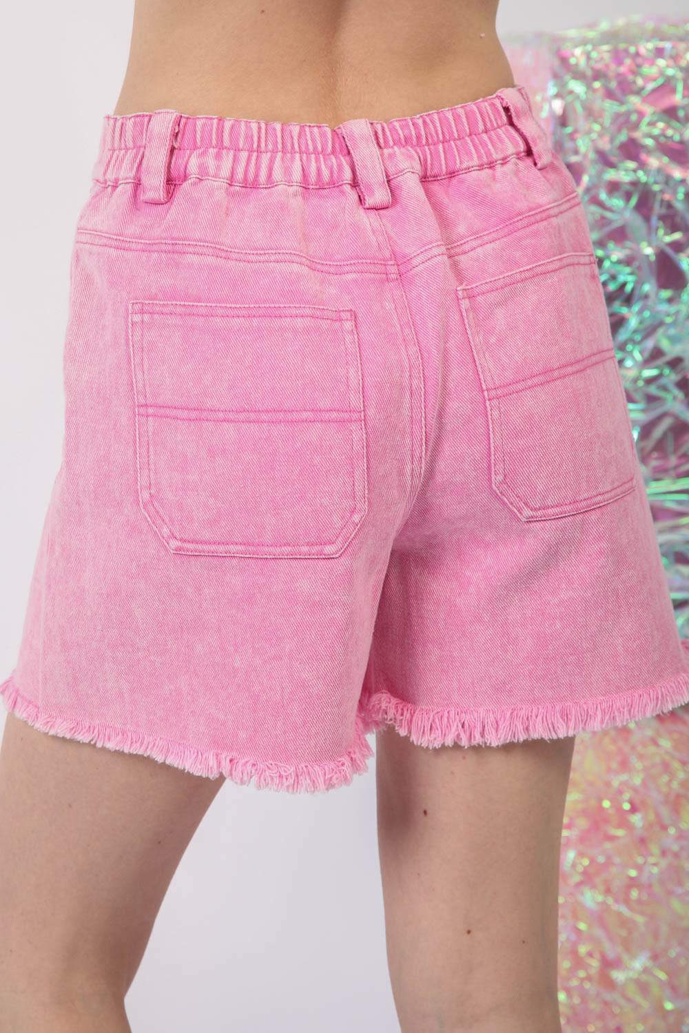 a woman wearing pink shorts and a pink top
