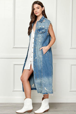 a woman wearing a denim dress and white boots