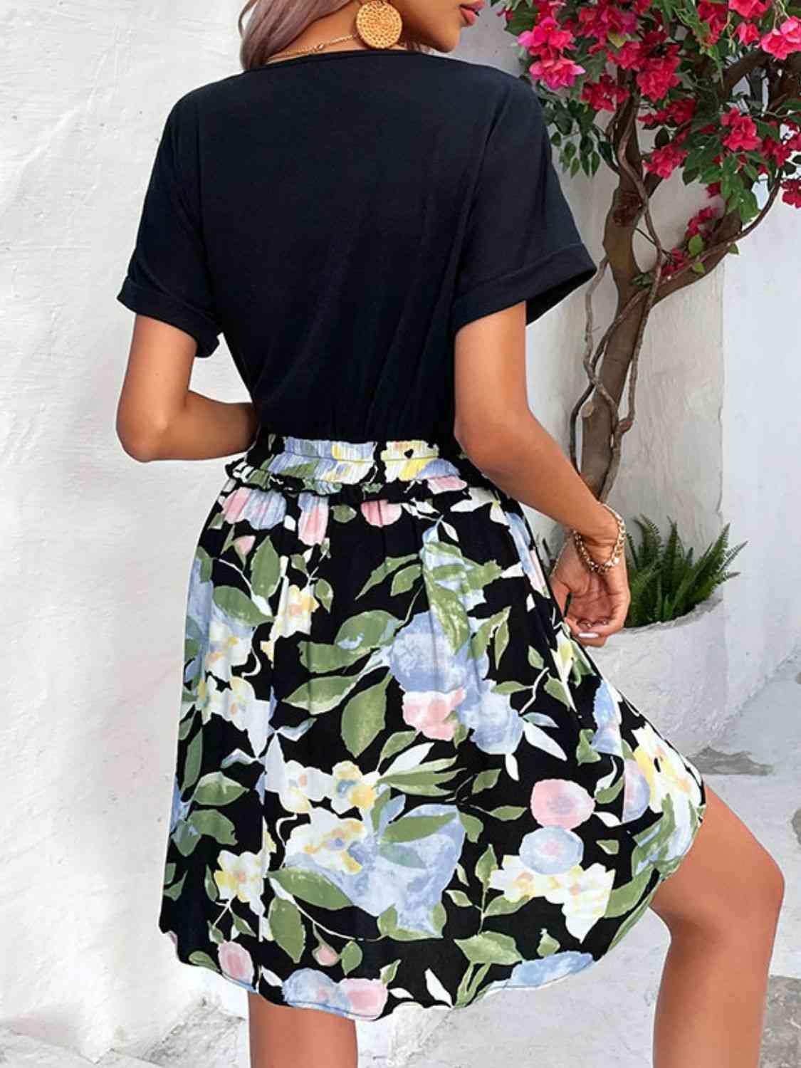 a woman wearing a black shirt and floral skirt