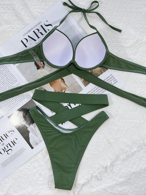 a pair of green bikinisuits laying on top of a bed